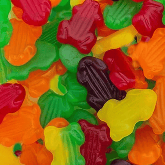 Assorted colorful gummy frogs on a textured surface