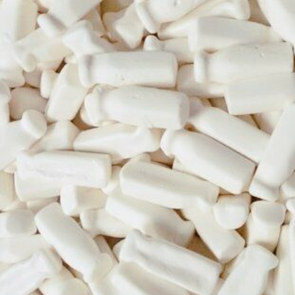 A close-up of white milk bottles candy, typically referred to as 'Milk Bottles: Cadbury Fresha', commonly found in retro sweet bags and candy mixes.