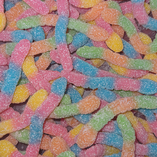 A close-up of colorful, sugary candy worms in various shapes and flavors, including Skittles and M&M's.