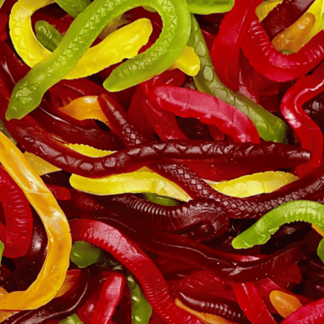 A close-up of colorful candy in the shape of snakes, featuring various colors such as red, yellow, green, and purple.
