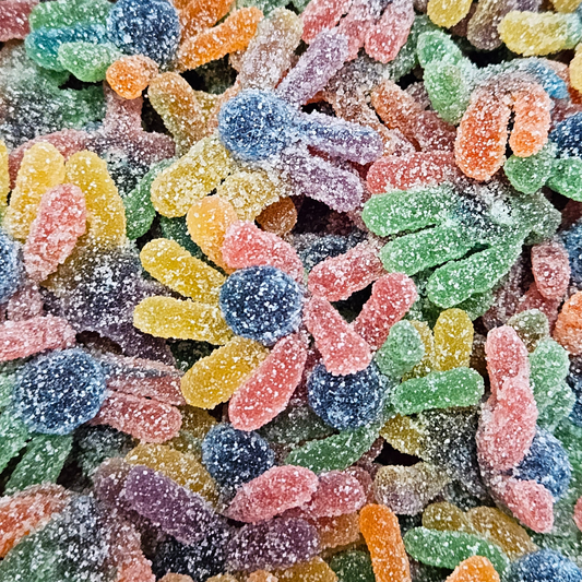 A close-up image of colorful sour candy pieces, resembling octopuses with multiple arms, coated in sugar.