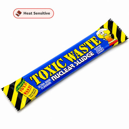 A single wrapped candy bar labeled 'TOXIC WASTE NUCLEAR SLUDGE' on a plain white background, with a small 'Heat Sensitive' callout in the upper left. The wrapper is predominantly blue with yellow text and black-and-yellow hazard stripes at the ends.
