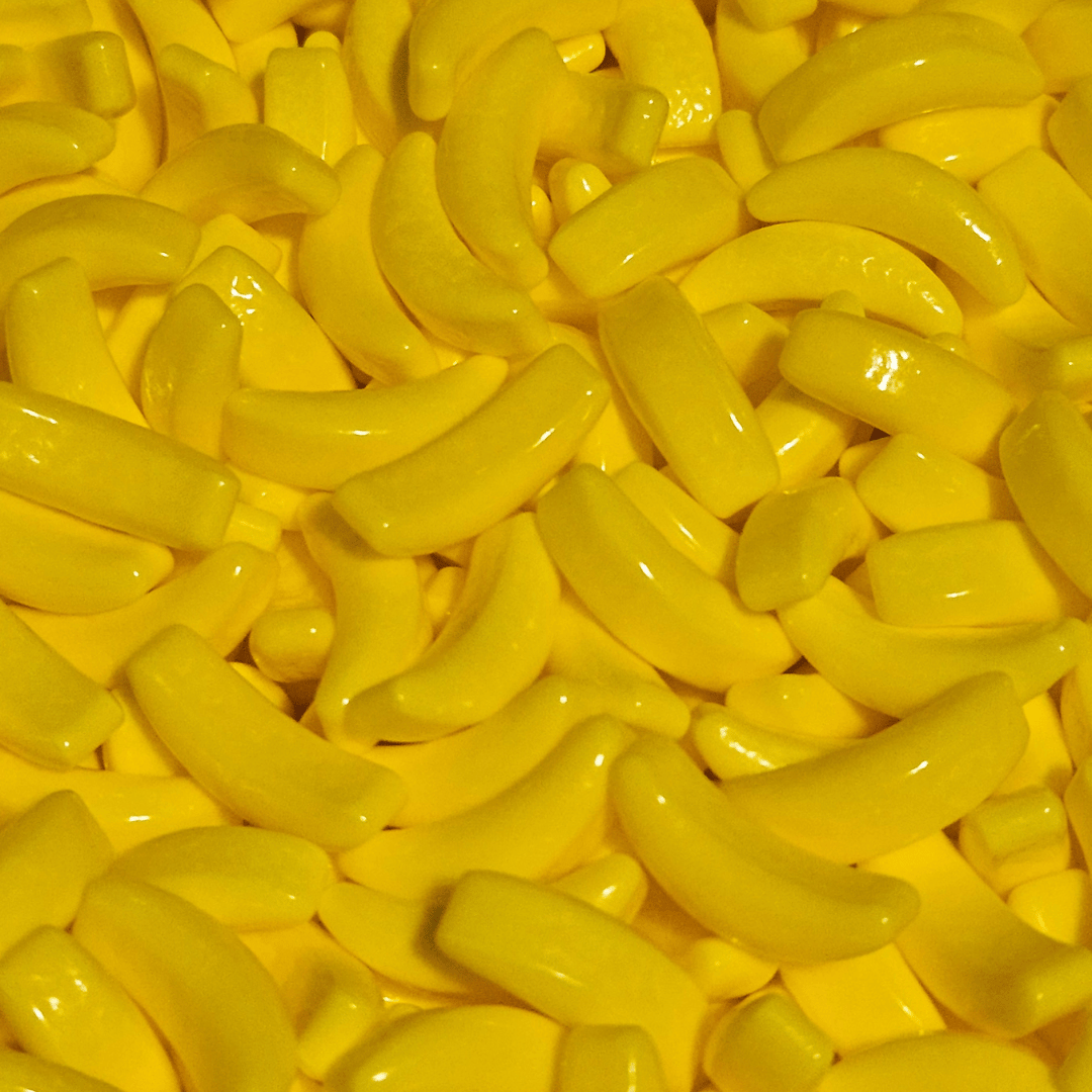 A close-up image of yellow hard candy shaped like bananas.