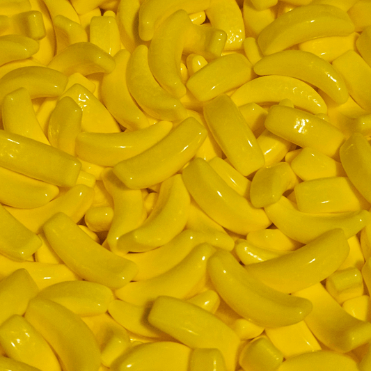 A close-up image of yellow hard candy shaped like bananas.