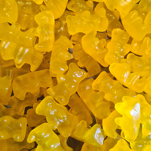 A close-up of yellow gummy candies shaped like bears.